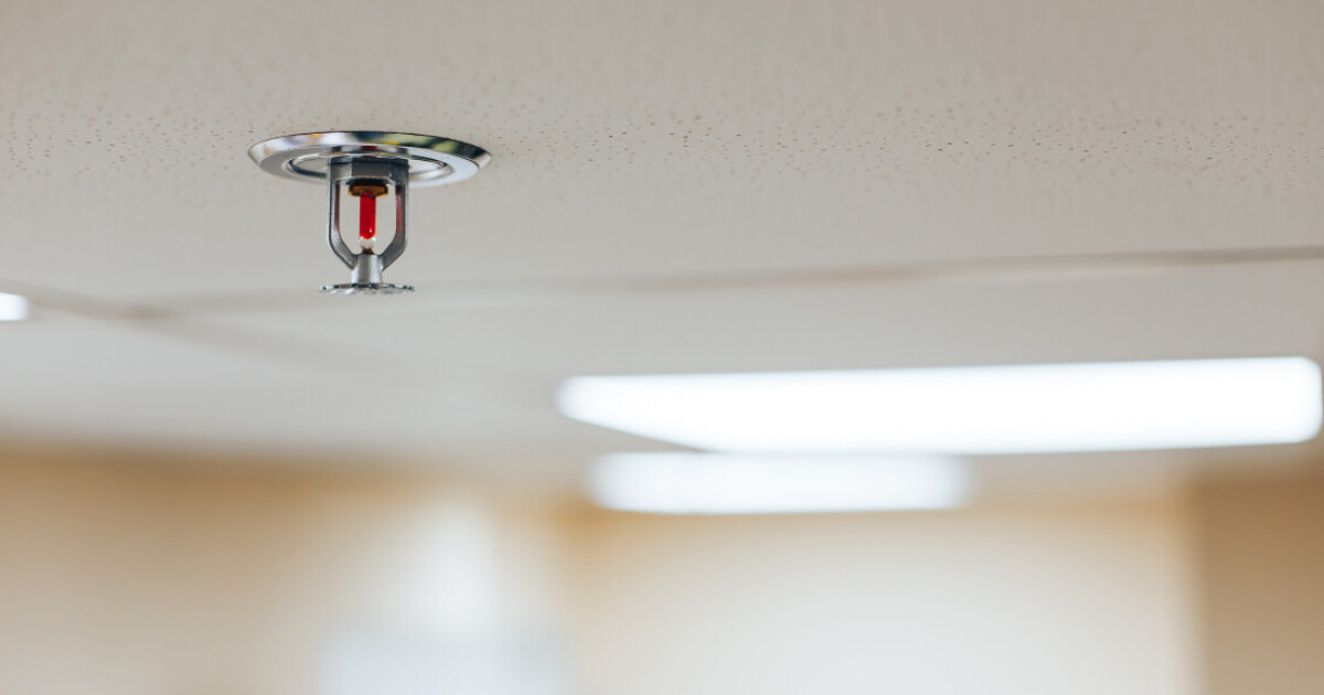 A fire sprinkler head fitted to a ceiling pipe in a commercial building